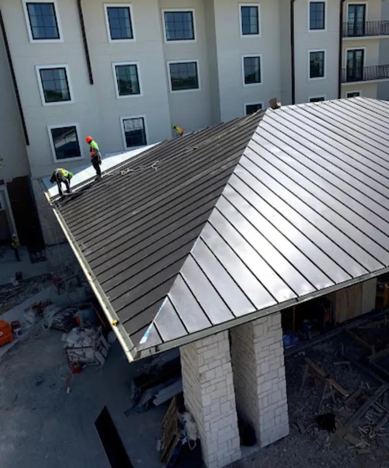 Crew installing standing seam metal roof panels on a commercial project in Land O' Lakes